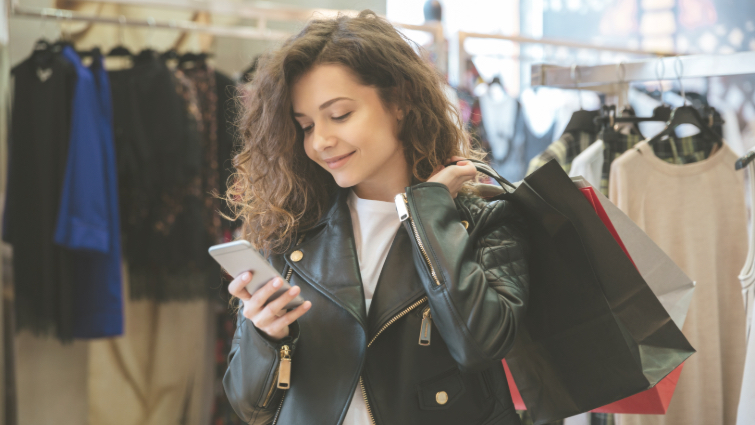 woman shopping with bags and looking at her phone